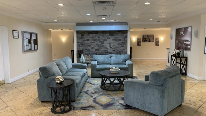 Interior lounge space with upholstered seating, fireplace accent wall, side tables, and modern decor