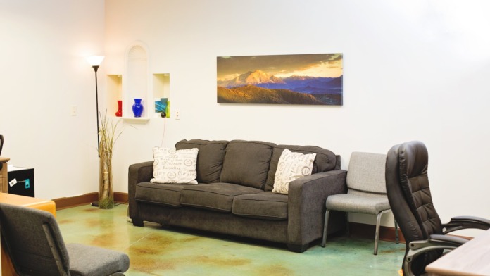 Interior leisure space with comfortable seating, floor lamps, landscape artwork, bookshelves, decorative items, and multiple seating options for group gatherings