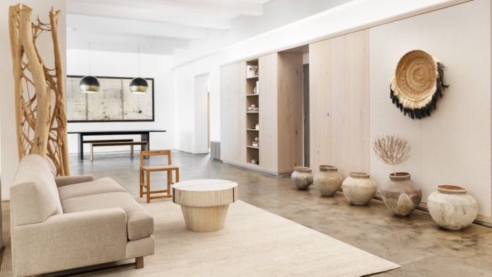 Interior common space with sofa seating, decorative pottery, wooden sculptures, and modern pendant lighting
