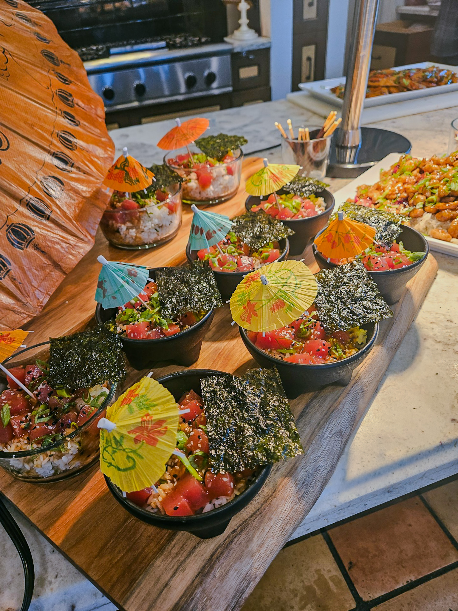 Interior food preparation area with sushi bowls decorated with cocktail umbrellas and kitchen equipment visible