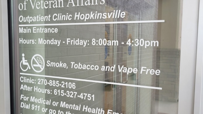 Interior main entrance door with posted hours, clinic contact information, and facility policies