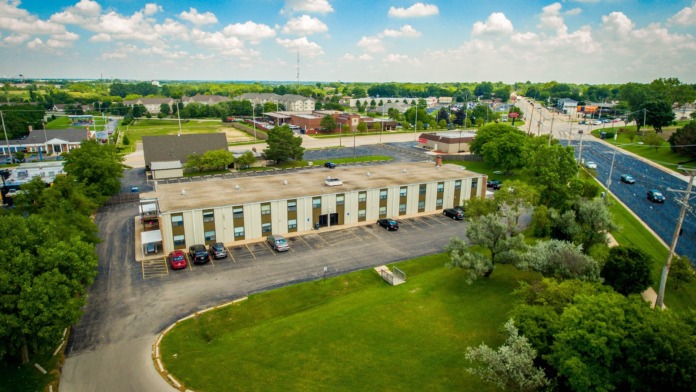 Exterior aerial view of treatment center building with parking lot, landscaped grounds, and surrounding residential area