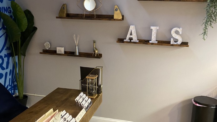 Interior wall display with wooden shelving, potted plants, bicycle, decorative objects, and hardwood flooring