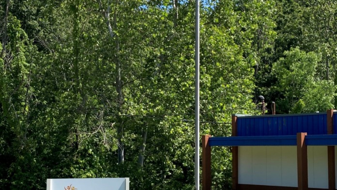 Exterior view of Spero Health entrance sign with facility name, mission statement, American flag, and wooded landscape background