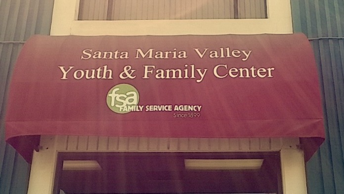 Exterior front entrance showing maroon awning with facility name and FSA Family Service Agency logo on storefront building