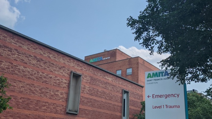 Exterior showing medical office building entrance with emergency and location signage, brick construction, and landscaping