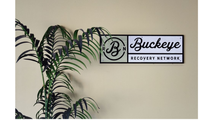 Interior wall displaying Buckeye Recovery Network logo with decorative palm plant