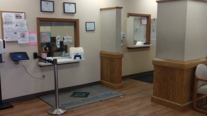 Interior front desk with mounted equipment, wall-mounted certificates, signage, and wood paneling throughout.