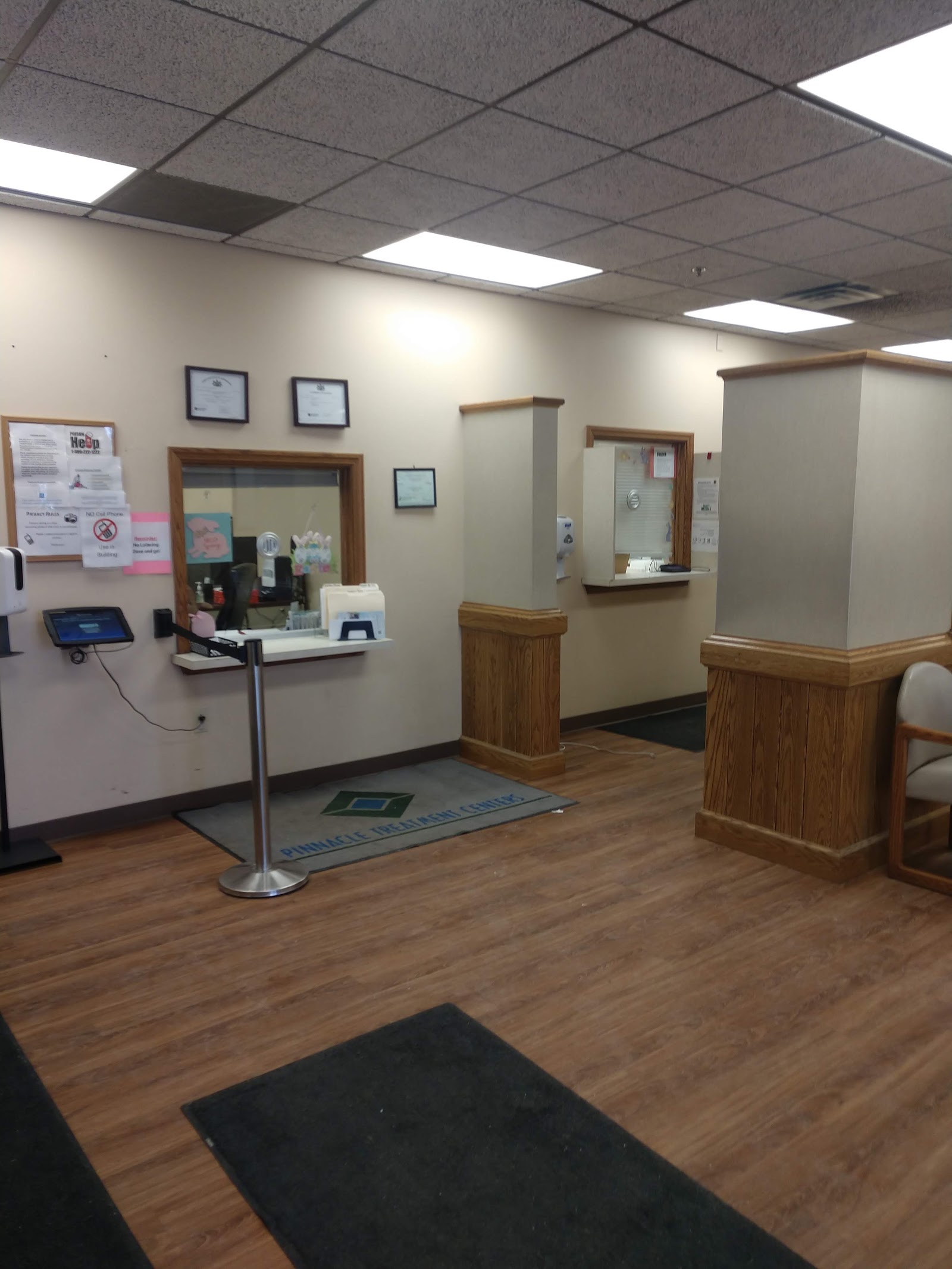 Interior front desk with mounted equipment, wall-mounted certificates, signage, and wood paneling throughout.