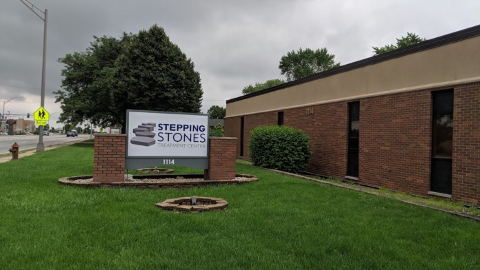 Exterior front entrance with Stepping Stones Treatment Center sign, brick building facade, and landscaped grounds