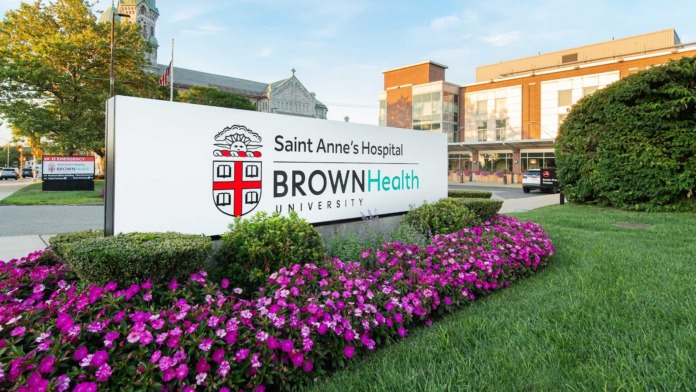 Exterior facility sign for Saint Anne's Hospital Brown Health University with colorful floral landscaping and modern building facade