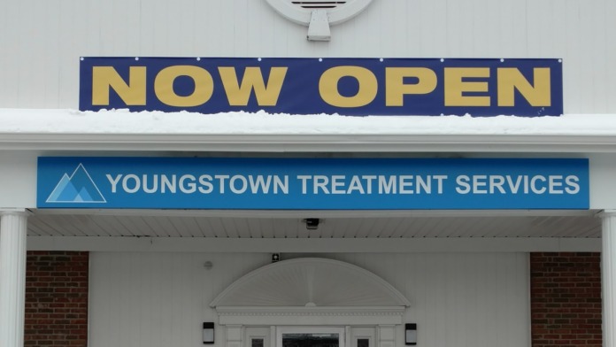 Exterior front view showing NOW OPEN banner and Youngstown Treatment Services signage with entrance