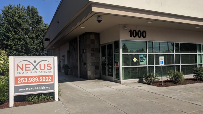 Facility front with white signage board displaying contact information, phone number, and address 1000