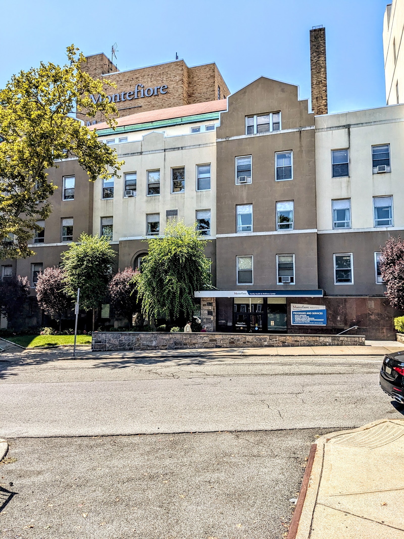 Exterior multi-story brick hospital building with Montefiore signage and regular window pattern across four stories