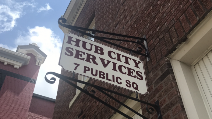 Exterior signage for Hub City Services mounted on brick building facade at 7 Public Square