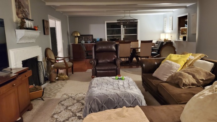 Interior common room with multiple seating areas, fireplace, exposed beams, and multiple doorways