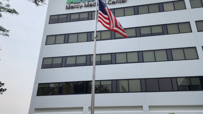Exterior front view of main medical center building with AMITA Health and Mercy Medical Center signage, American flag, and landscaping