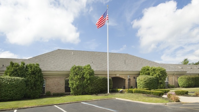 Exterior view of single-story brick treatment facility with landscaping, parking area, and American flag