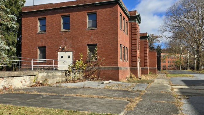 Exterior view of two-story red brick treatment facility building with entrance and landscaped grounds.