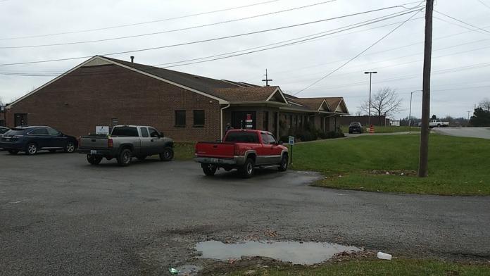 Exterior brick treatment facility building with covered entrance, parking area, and landscaped grounds