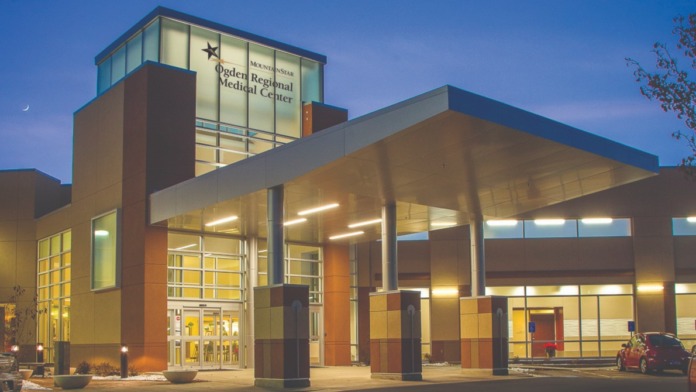 Exterior view of Ogden Regional Medical Center main entrance illuminated at dusk with signage and covered entry area