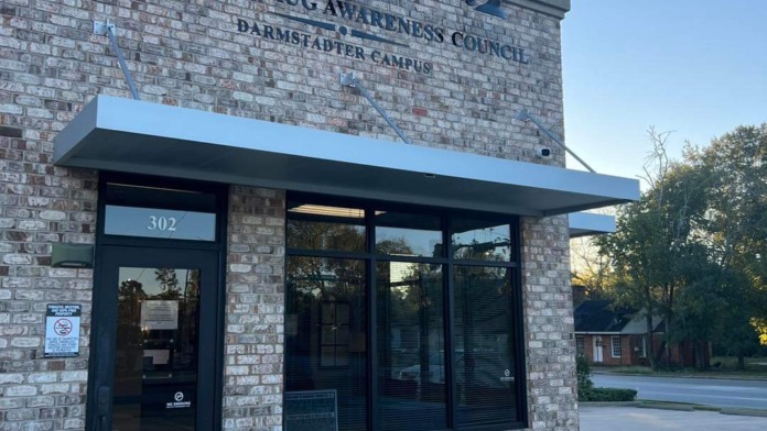Exterior view of treatment center main entrance with brick facade, dark blue awning, address marker 302, and facility signage