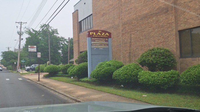 Exterior view of brick building with AppleGate facility signage, landscaped shrubs, and building entry.