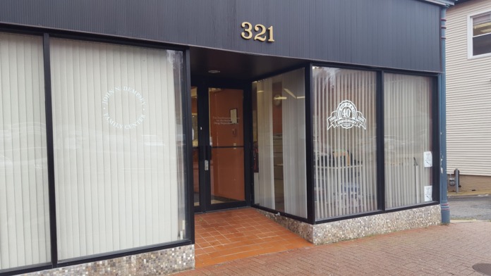 Exterior view of treatment facility entrance showing address number 321, glass doors, facility signage, and brick base