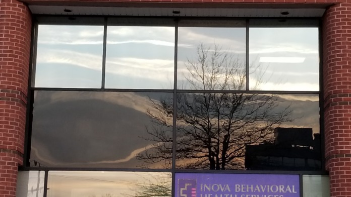 Exterior front entrance of nova Behavioral Health Services showing brick facade, address 6910, purple sign, and glass entry doors