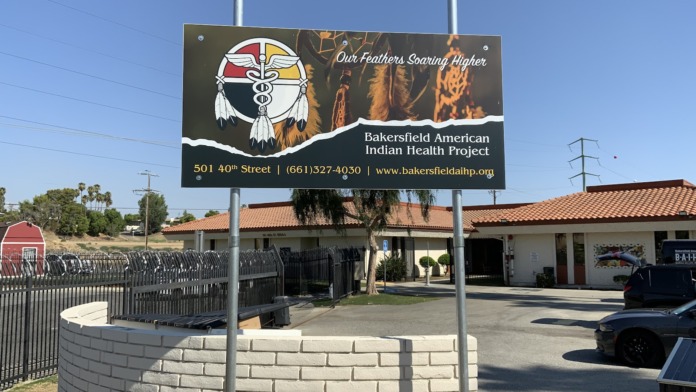 Exterior of treatment facility with signage pole, entrance gates, and building with terra cotta roof visible from street