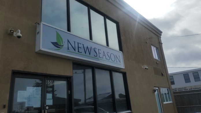 Exterior front entrance of New Season Treatment Center showing main sign with green leaf logo, address 659, and large windows