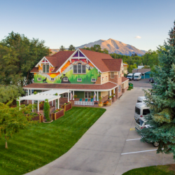 Exterior view of Jaywalker Lodge showing red brick residential building with manicured lawn, driveway, and mountain backdrop