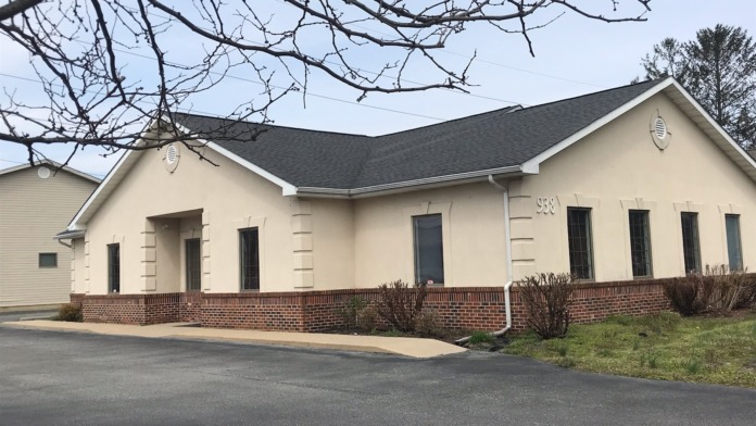 Exterior view of single-story cream and brick treatment facility with multiple windows, entrance portico, and manicured landscaping