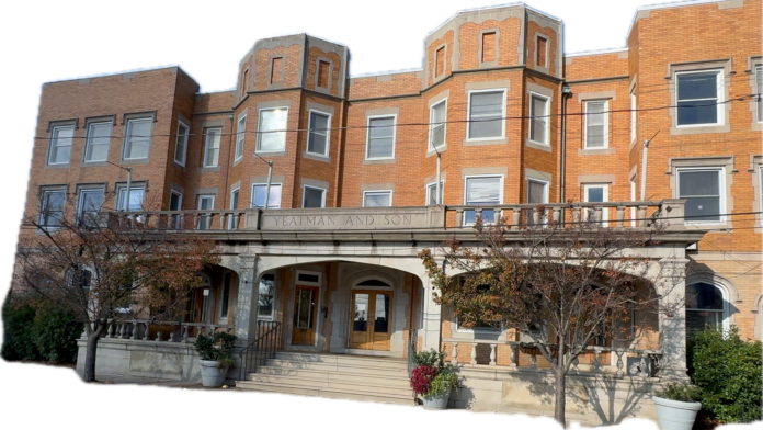 Exterior view of brick treatment facility showing main entrance with stone archway, multiple stories, and landscaped grounds