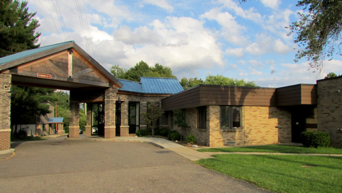 Exterior treatment facility showing main entrance with brick and stone construction, covered portico, and landscaping.
