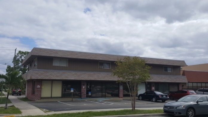 Exterior view of two-story treatment facility with brick construction, main entrance, windows, parking lot, and accessibility features.