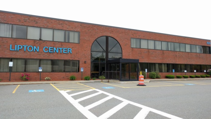 Exterior view of Lipton Center brick building with main entrance, parking lot with accessible parking spaces, and landscaping