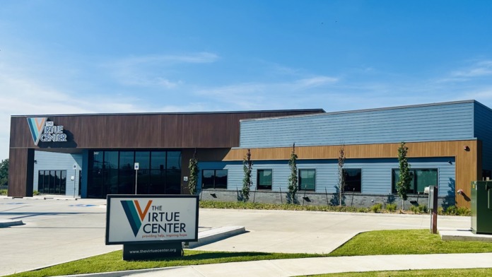 Exterior front of The Virtue Center showing main entrance, landscaping, and facility identification sign