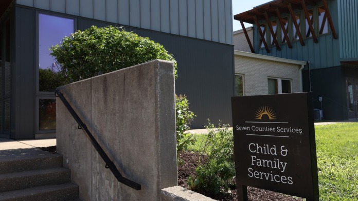 Exterior view of Seven Counties Services main entrance with concrete steps, landscaping, and facility identification sign