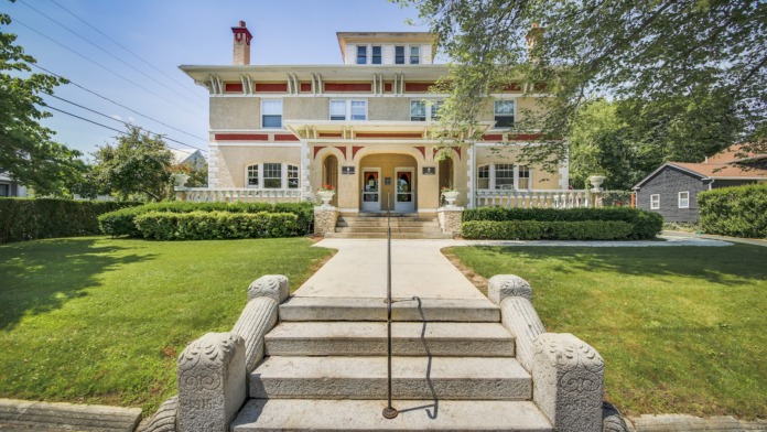 Exterior view of historic treatment center main entrance with symmetrical stone steps, ornate railings, and classical architectural details