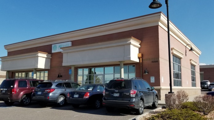 Exterior front view of treatment facility with brick facade, large windows, entrance doors, and visitor parking area