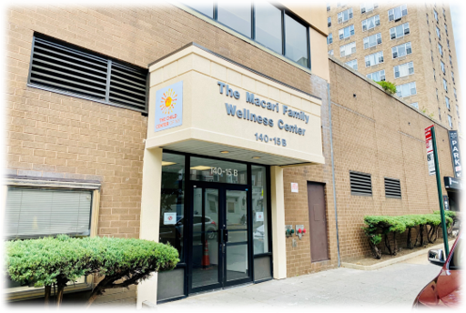 Exterior view of The Iaconi Family Wellness Center entrance at 140-15B with brick facade, glass doors, and facility signage