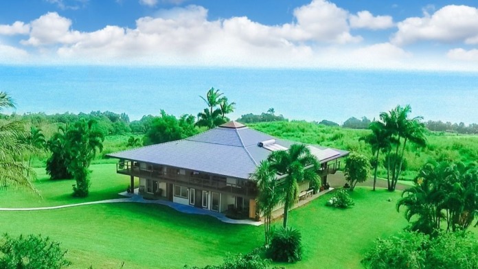 Exterior aerial view of main treatment facility building surrounded by green grounds and palm trees