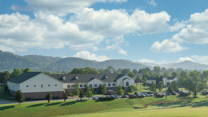 Exterior view of Cumberland Heights treatment facility showing main buildings, manicured grounds, and mountain backdrop