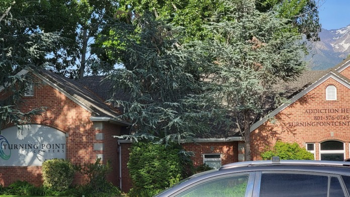 Exterior view of brick treatment facility building with Turning Point Centers logo sign, landscaping, and mountain backdrop