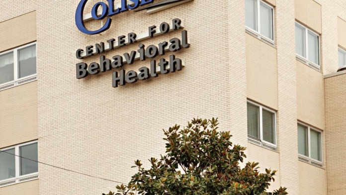 Exterior maternity center entrance with Family This signage, brick facade, planted flowers, and accessible entrance