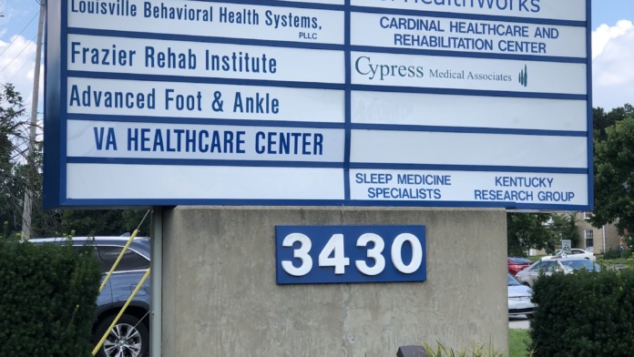 Exterior multi-tenant medical center directory sign listing JourneyPure Louisville and other healthcare providers with landscaping.