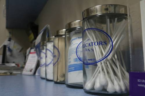 Interior view of medical supplies stored in labeled containers on countertop in treatment facility