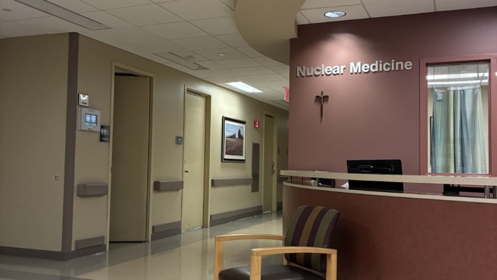 Interior medical department reception area with curved architectural ceiling, comfortable seating, and service counter