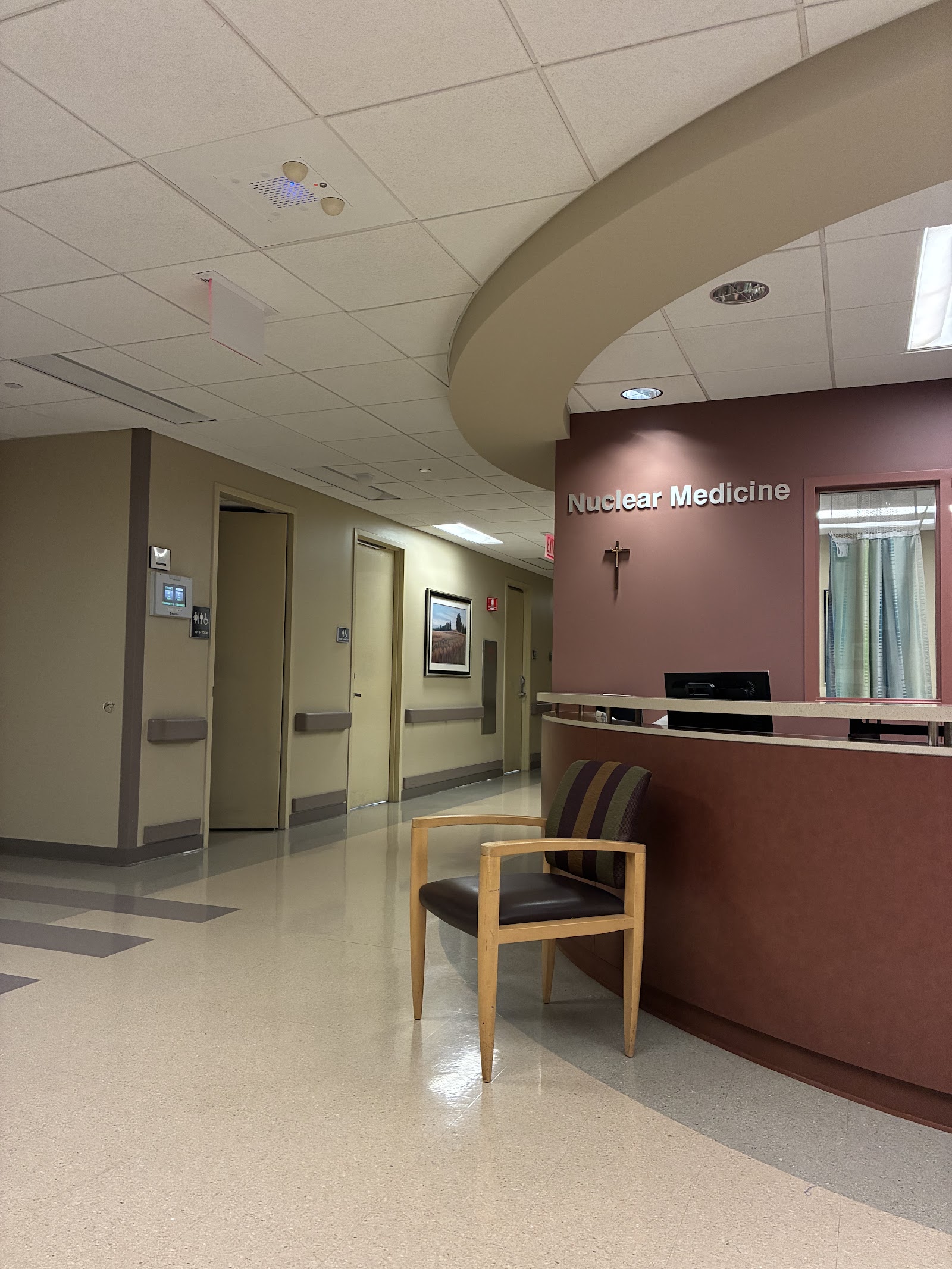 Interior medical department reception area with curved architectural ceiling, comfortable seating, and service counter